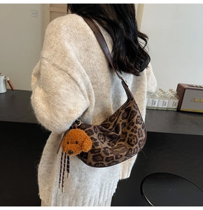 Detail of leopard print hobo bag with teddy charm and adjustable leather strap