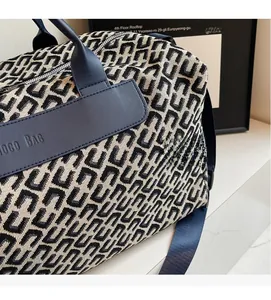 Detailed macro view of the textured jacquard fabric and leather handle on a travel bag