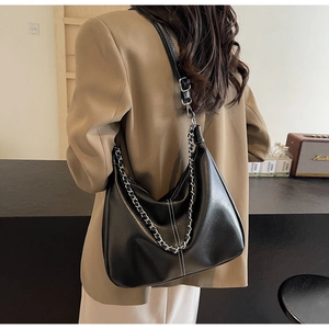 Detail der schwarzen Hobo-Tasche mit Kontrastnähten und klobiger silberner Kette