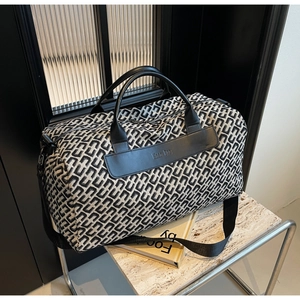 Close-up of geometric pattern travel bag with leather handles and Nice BAG patch detail