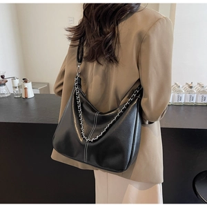 Detailaufnahme der schwarzen matten Ledertasche mit weißen Kontrastnähten und Silberkette