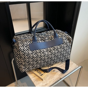 Detail showing high-capacity travel bag texture with Moco Bag logo and blue leather strap