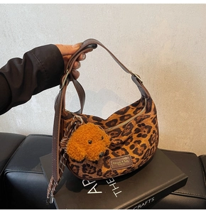 Leopard print crossbody bag detail with brown strap and plush dog keychain accessory