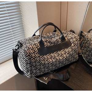 Detail of geometric pattern texture and Nuo Bo embossed leather patch on travel bag