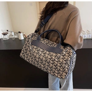 Detail of geometric weave travel bag with leather handles and detachable shoulder strap