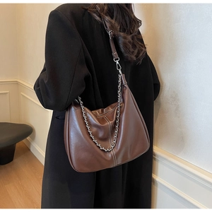 Detail der braunen Vintage-Tasche mit Silberkette und verstellbarem Schultergurt