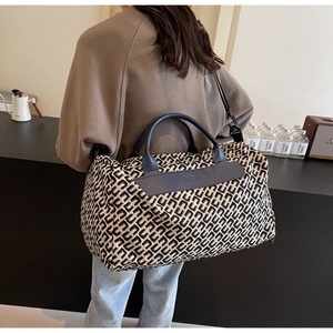 Large capacity travel tote bag with geometric patterns shown on a female model