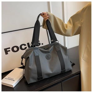 Detail of dark grey large travel bag showing durable waterproof fabric and sturdy handle