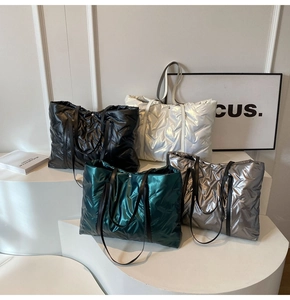 Detail von gesteppten Daunen-Tote-Bags in Metallic-Farben mit Leder-Schultergurt