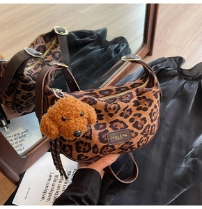 Detail of leopard print plush crescent bag with brown strap and teddy dog charm