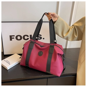 Detail of rose red large travel bag showing water-resistant texture and handle