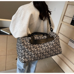 Close-up of geometric pattern travel bag with leather handles and wide shoulder strap
