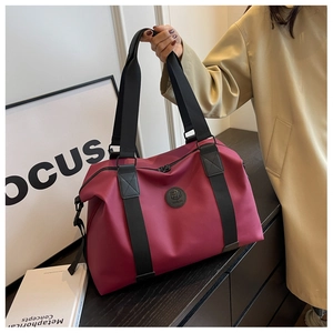 Detail of waterproof dark pink travel tote bag with durable black woven handles