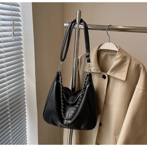 Detail der schwarzen Achseltasche mit weißen Kontrastnähten und silbernem Kettenakzent