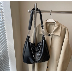 Detail einer schwarzen Hobo-Tasche aus Leder mit weißen Kontrastnähten und Silberkette