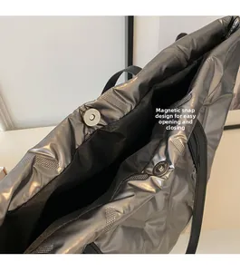 Detailaufnahme des Magnetverschlusses und des schwarzen Innenfutters der silbernen Tasche