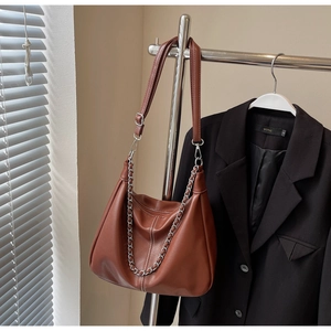 Detailansicht der braunen Hobo-Tasche aus Leder mit Silberkette und verstellbarem Gurt