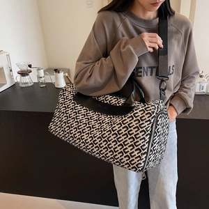 Large travel tote with geometric weave pattern, black leather handles and crossbody strap