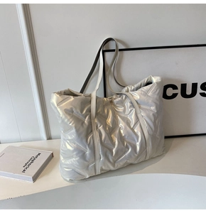 Detail der metallisch gesteppten Shopper Tasche mit glänzendem Finish und Henkeln