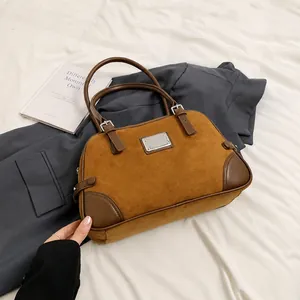 Dettaglio della borsa Boston in pelle scamosciata marrone con fibbie in metallo argento