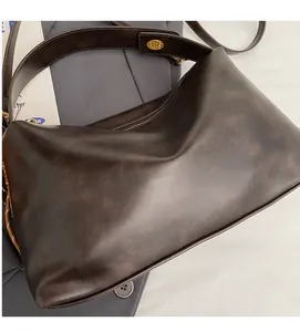 Detail of soft matte leather tote with vintage gold buckle and adjustable strap