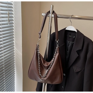 Detail der dunkelbraunen Hobo-Tasche mit Silberkette und Kontrastnaht am Schultergurt
