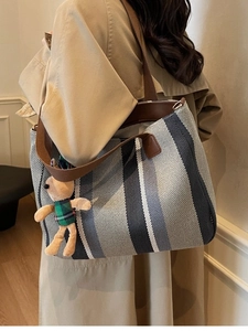 Large striped canvas tote bag with brown leather straps and cute bear charm decor