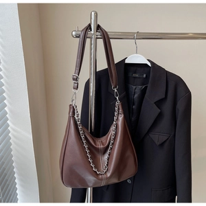 Detail der dunkelbraunen Hobo-Tasche mit Kontrastnaht, Silberkette und Lederriemen