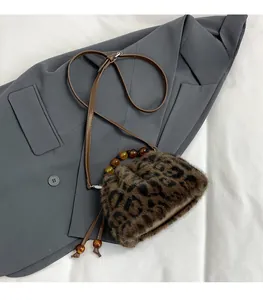 Détail du sac seau en fausse fourrure léopard avec poignée en perles d'ambre et cuir