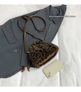 Sac seau en fausse fourrure léopard montré à côté d'un smartphone pour comparer la taille