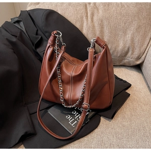 Detail der braunen PU-Ledertasche mit weißen Kontrastnähten und silberner Kette