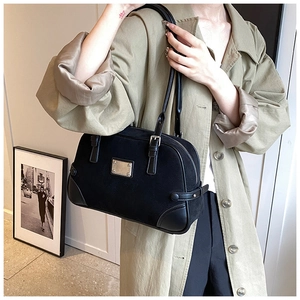 Dettaglio borsa Boston vintage in pelle scamosciata nera con fibbie su un modello
