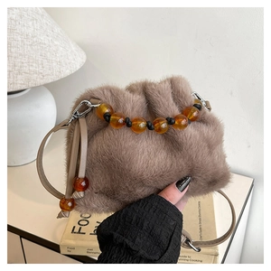 Détail du sac en fausse fourrure marron avec perles ambrées et texture douce de nuage