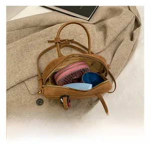 Vue de dessus de l'intérieur du sac à main en daim marron montrant sa capacité de rangement