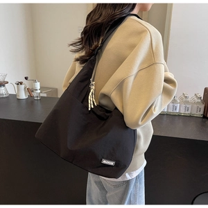 Detailansicht der großen schwarzen Nylon-Tote Bag mit gewebtem Reißverschluss-Anhänger