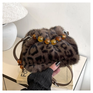 Détail du sac à main en peluche léopard avec perles ambrées et bandoulière en cuir