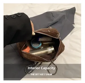 Macro view of the spacious internal capacity in dark brown quilted chain pillow bag