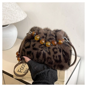 Détail du sac seau en peluche léopard avec poignée en perles d'ambre et bandoulière cuir