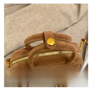 Détails du sac en daim marron caramel avec fermeture éclair dorée et anses solides