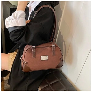 Dettaglio della borsa Boston vintage in pelle satinata rosso-marrone con fibbia argentata