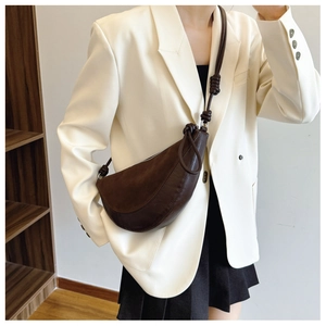 Detail of coffee brown dumpling bag featuring textured stitching and knotted shoulder strap