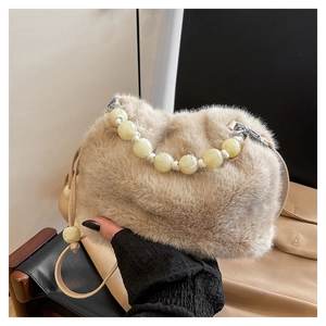 Détail du sac cœur en fausse fourrure beige avec de grandes perles décoratives