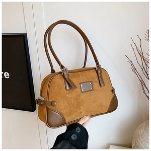 Dettaglio borsa Boston in camoscio marrone con finiture in pelle scura e placca argentata