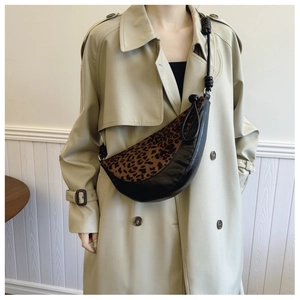 Detail of leopard print crescent bag with black leather base and rope strap design