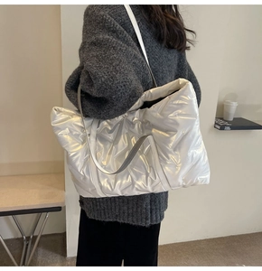 Gesteppte Puffer-Tasche in Silberweiß von einem Model über der Schulter getragen
