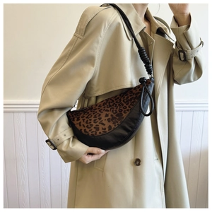 Detail of crossbody crescent bag featuring leopard print suede and black leather panels