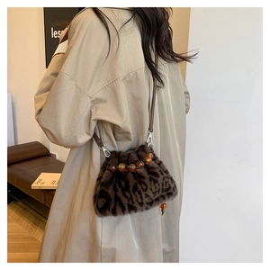 Détails du sac seau en fausse fourrure léopard avec perles ambrées et bandoulière en cuir