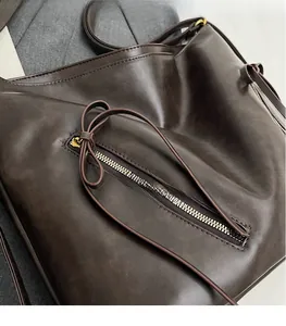 Close-up of retro dark coffee leather backpack with metal zipper and strap details