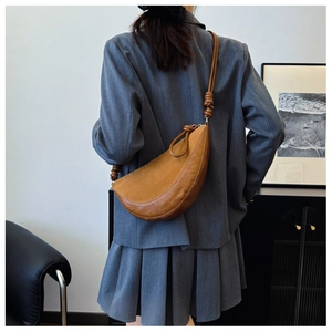 Detail view of the brown spliced suede and leather material with knotted shoulder strap