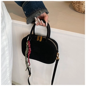Détail du sac bowling noir mat avec logo de la marque, zip en métal et breloque colorée